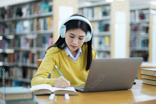 Student studying at library with laptop.