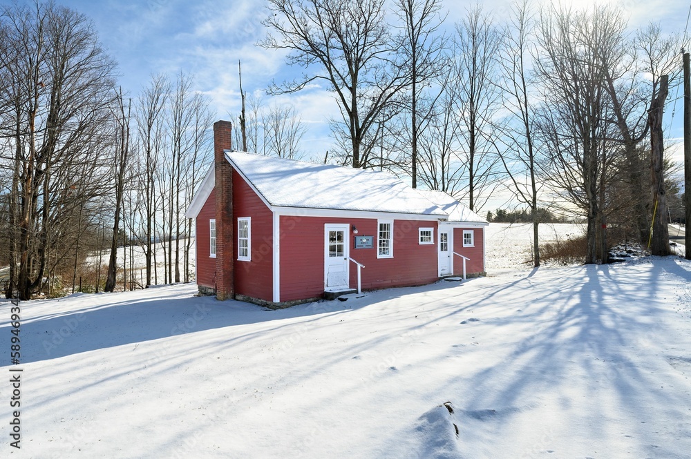 Beautiful red wooden house with a cloudy blue sky in the background on a sunny winter day Beautiful red wooden house with a cloudy blue sky in the background on a sunny winter day