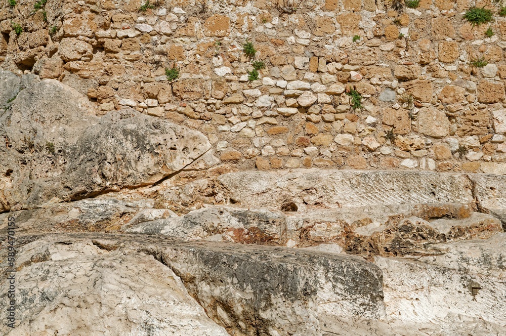 stone wall of a castle complex with a small room and arch