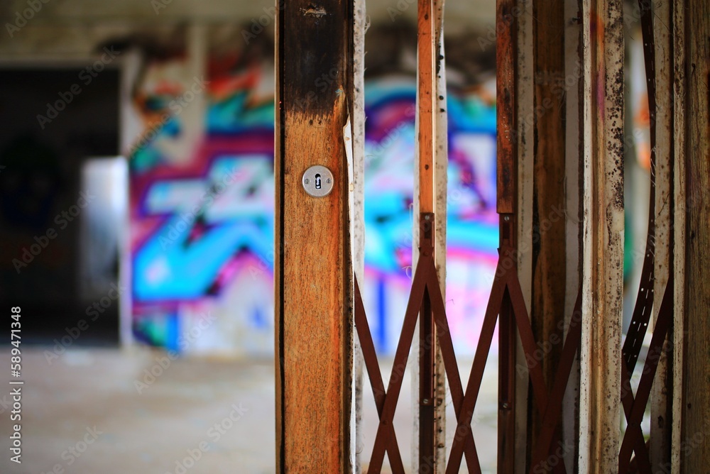 Ripped wooden door with blurry spray painted wall in the background