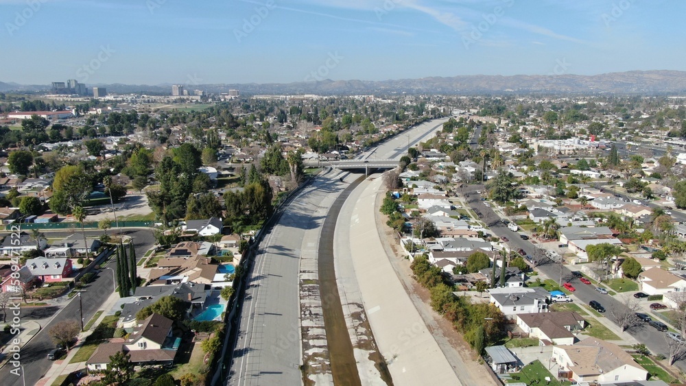 Drone shot of a bridge crossing over a water canal in a residential neighborhood on a sunny day