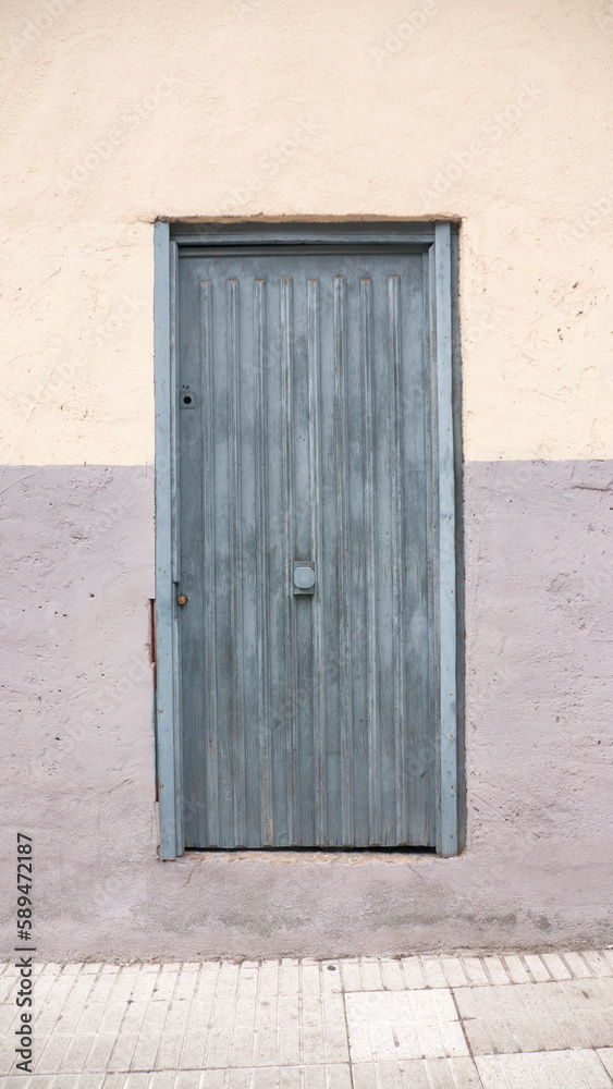 Puerta rústica gris en pared gris y amarilla