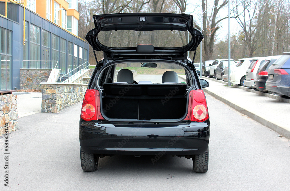 Small female city car with open empty trunk. Modern car open trunk. Car boot is open.
