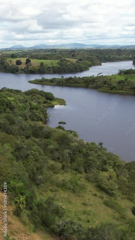 Mesmerizing view of a beautiful lake surrounded by grassy land under a cloudy sky Mesmerizing view of a beautiful lake surrounded by grassy land under a cloudy sky