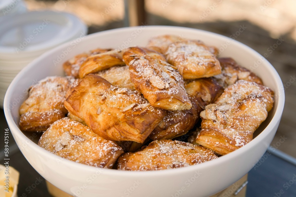 Closeup shot of a bowl of freshly baked pastries with powdered sugar Closeup shot of a bowl of freshly baked pastries with powdered sugar