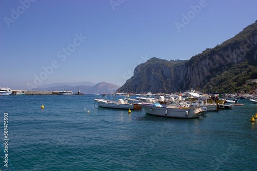 Beautiful shot of boats on the water near rocky cliffs on Capri Island, Naples, Italy