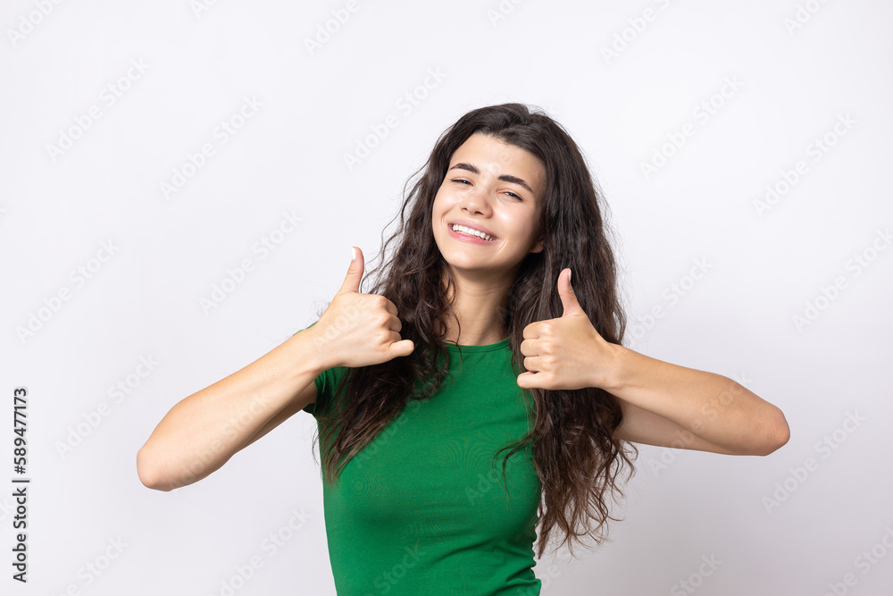Close-up portrait of attractive surprised girl, showing thumbs up gesture. Success luck concept. Close-up portrait of attractive surprised girl, showing thumbs up gesture. Success luck concept.