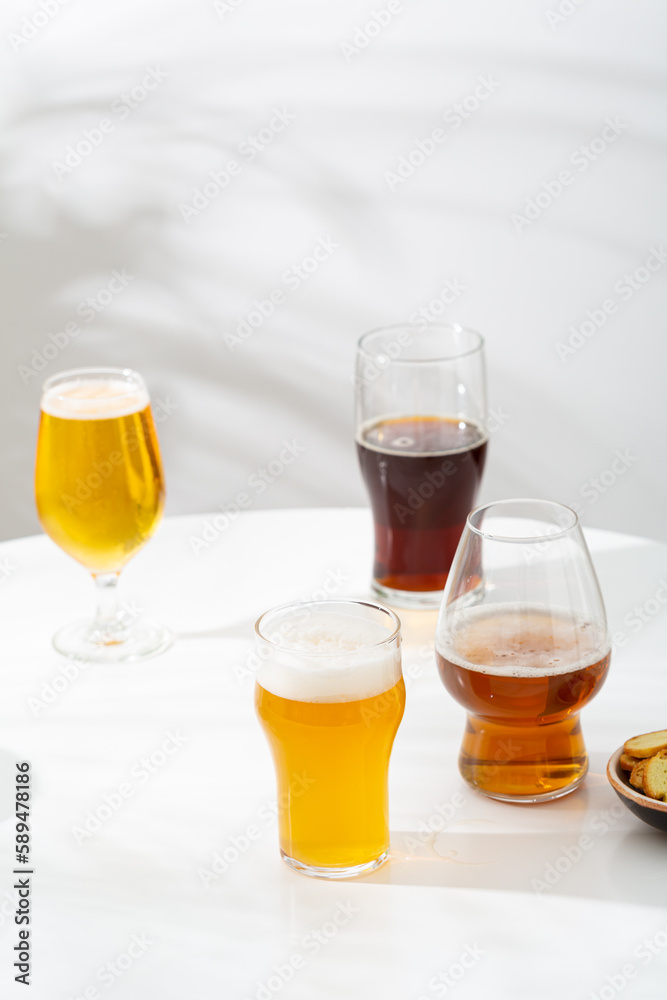 Several Glass with light beer dark empty on light background Several Glass with light beer dark empty on light background