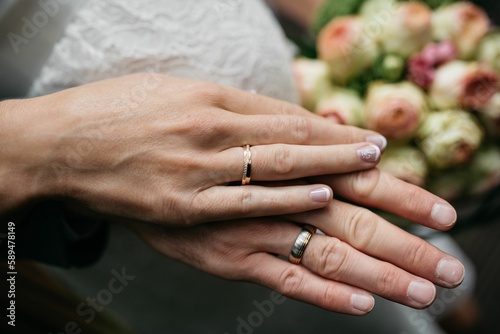 Closeup shot of the bride and groom hands with wedding rings