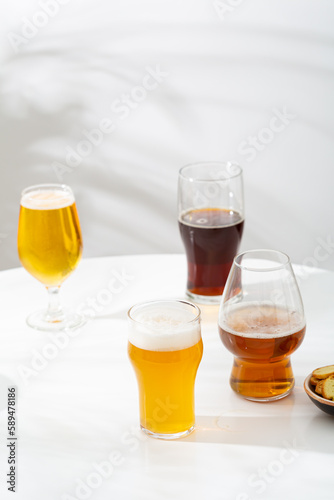 Several Glass with light beer dark empty on light background