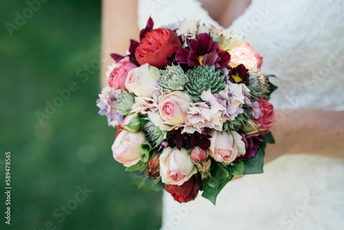 Konstfotografi Closeup of a wedding bouquet and a bride holding it blurred background