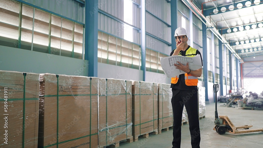 Professional caucasian elegant young engineer holding a radio communication talking with colleague to inspect the products in the factory