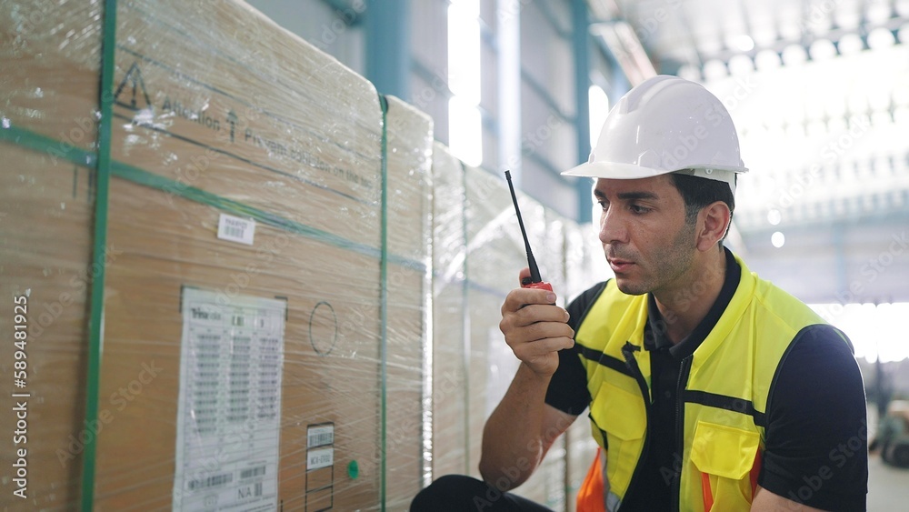 © M Stocker - Professional caucasian elegant young engineer holding a radio communication talking with colleague to inspect the products in the factory