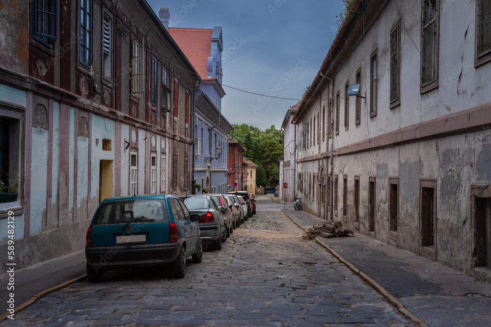 Typical central european and eastern european street in Petrovaradin, Serbia, next to novi sad, in a residential vintage area with cars parked.