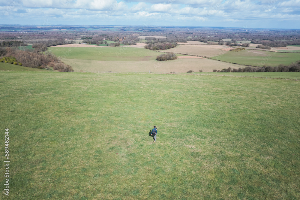 lone hiker walking along footpath in the countryside of Kintbury, Berkshire, England
