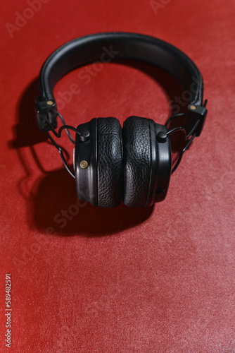 Wireless black headphones on a red background. View from above.