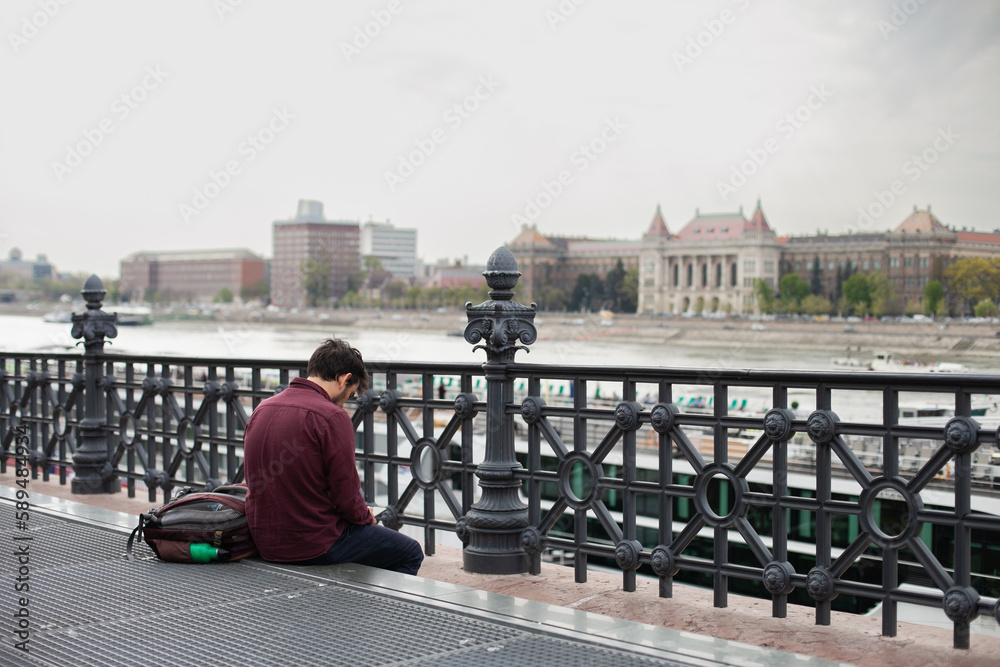 Man or guy from behind in Budapest, sightseeing. Male tourist using phone. Tourism in Europe. Man or guy from behind in Budapest, sightseeing. Male tourist using phone. Tourism in Europe.