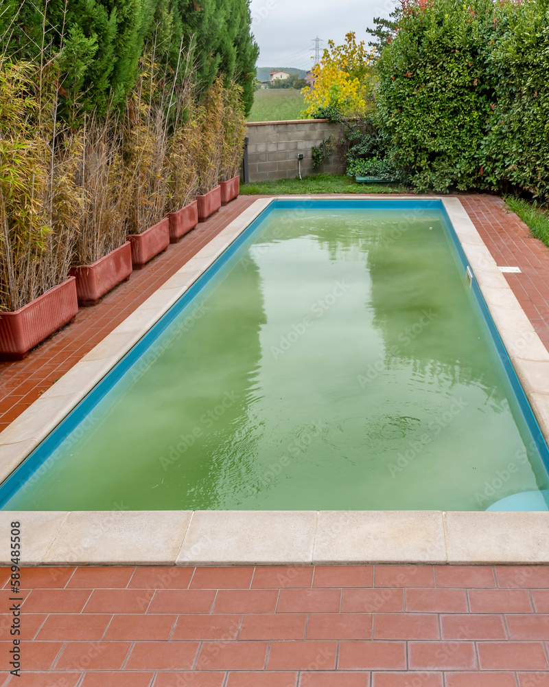 Following shock chlorination, the water in a swimming pool is white and cloudy