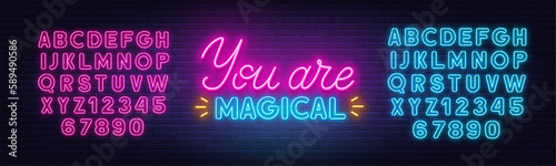 You Are Magical neon lettering on brick wall background.