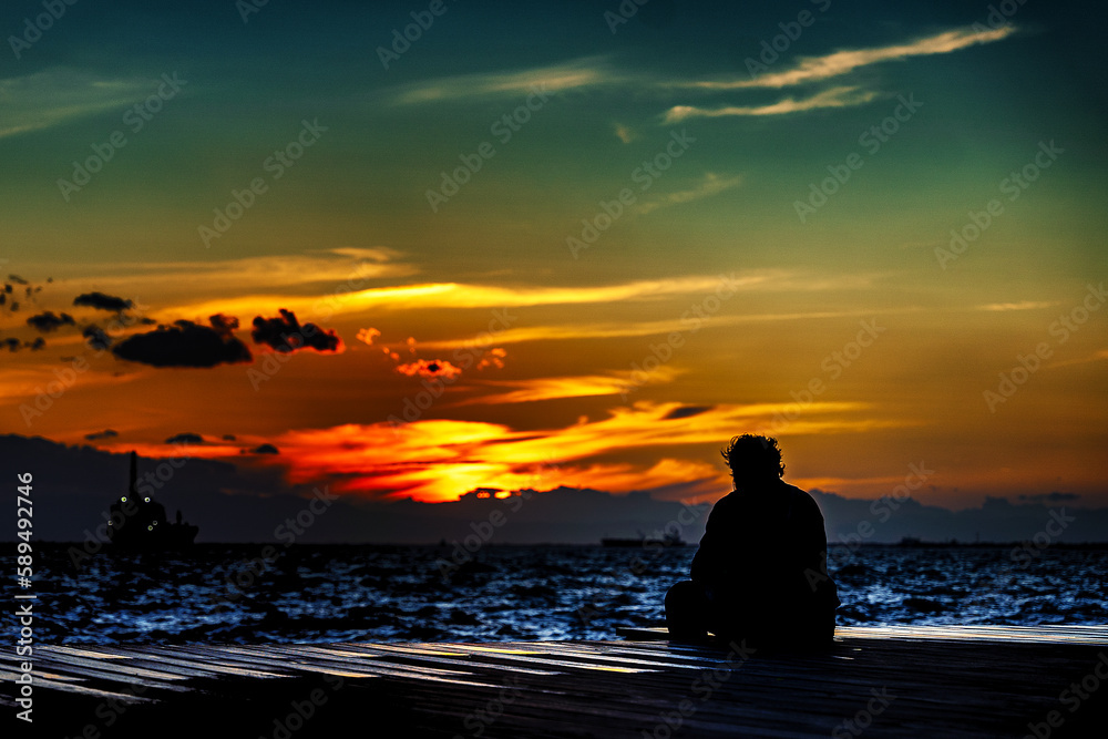 Mensch bei Sonnenuntergang auf Pier