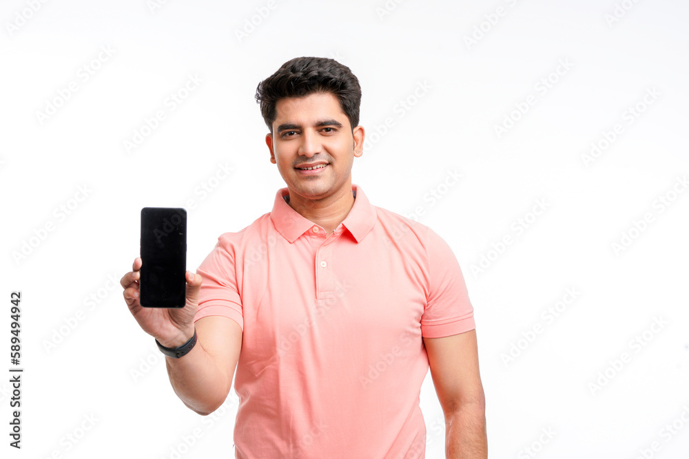 Young man standing in casual t shirt and showing smartphone screen. Young man standing in casual t shirt and showing smartphone screen.