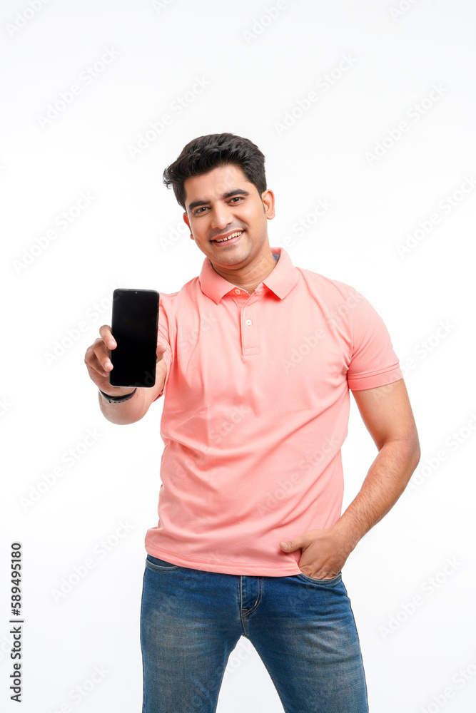 Young man standing in casual t shirt and showing smartphone screen. Young man standing in casual t shirt and showing smartphone screen.