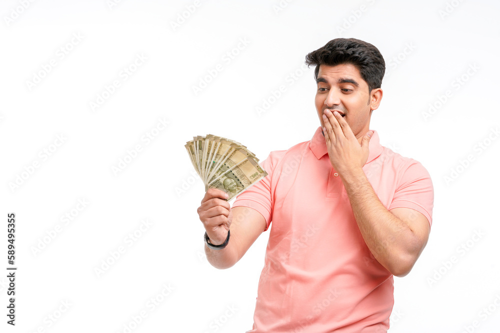 Indian man holding five hundred bank note in hand and giving unbelievable expression. Indian man holding five hundred bank note in hand and giving unbelievable expression.
