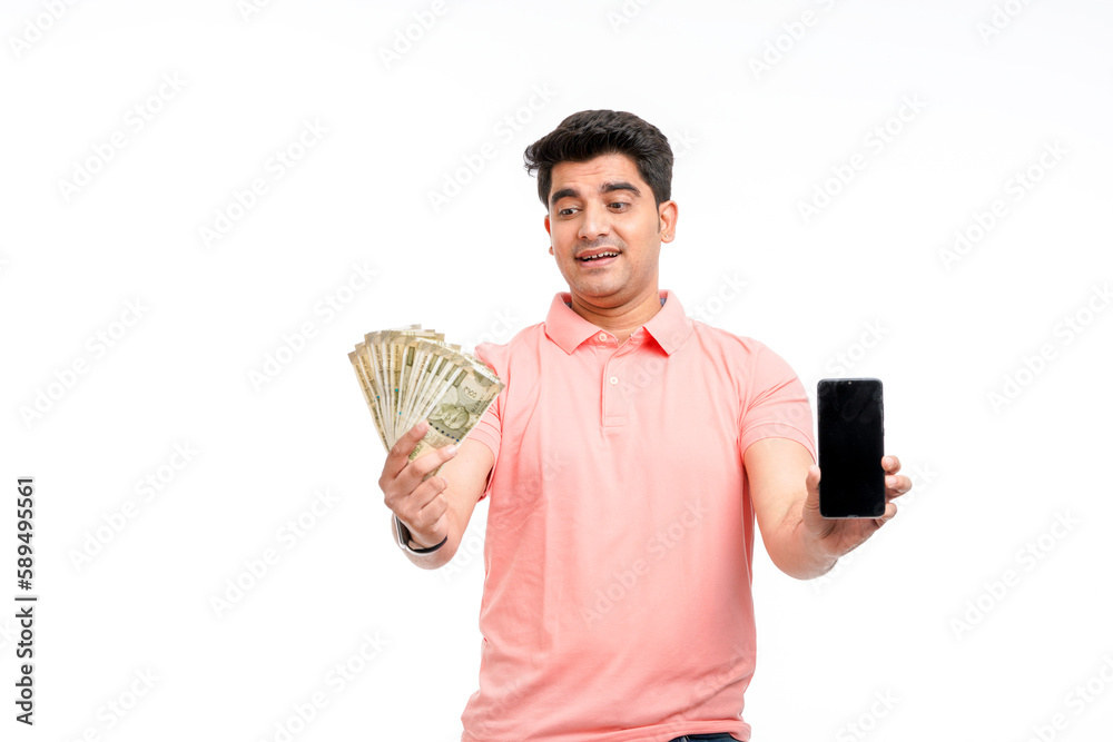 Young indian man showing indian currency and smartphone screen. Young indian man showing indian currency and smartphone screen.