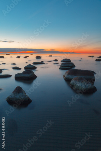 Sunset long exposure on the Baltic sea coast with boulders