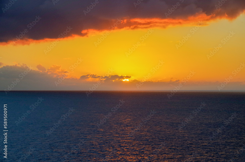 Beautiful dramatic sunset sunrise twilight blue hour seascape scenery over ocean with horizon and clouds cloudscape from cruiseship cruise ship liner sail away from Nassau, Bahamas