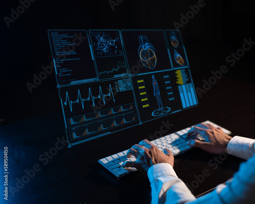 Close-up of male hands on a keyboard in the dark in front of a virtual menu. Readings on the life support monitor. 
