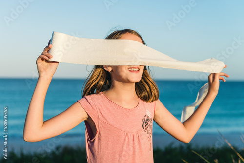 girl being silly with toilet paper, making a blindfold photo