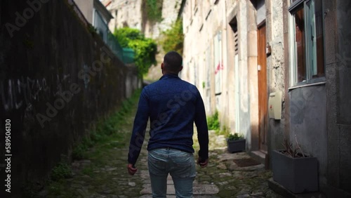 Tourist man walking though poor neiborhood narrow streets where poverty can be seen in Oporto, Portugal. photo