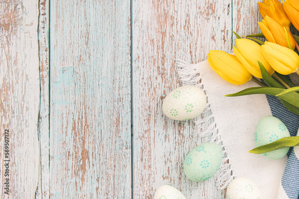 Easter decoration, flat lay, Easter eggs with yellow tulips on wooden table Easter decoration, flat lay, Easter eggs with yellow tulips on wooden table