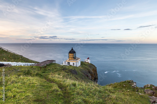 View of St Abb's Lighthouse along the coastline with cliffs, St Abb's Head, Eyemouth, United Kingdom. photo