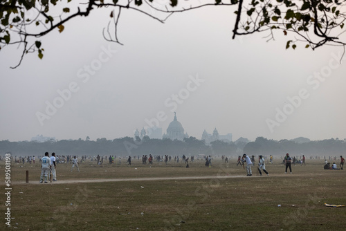 Maidan, Kolkata, India - 18 December 2022: view of people playing cricket in the largest playgroud of Maidan. photo