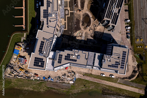 Top down aerial view of luxury Kade Zuid apartment complex construction at sunset at riverbank of river IJssel part of countenance cityscape of tower town Zutphen.  photo