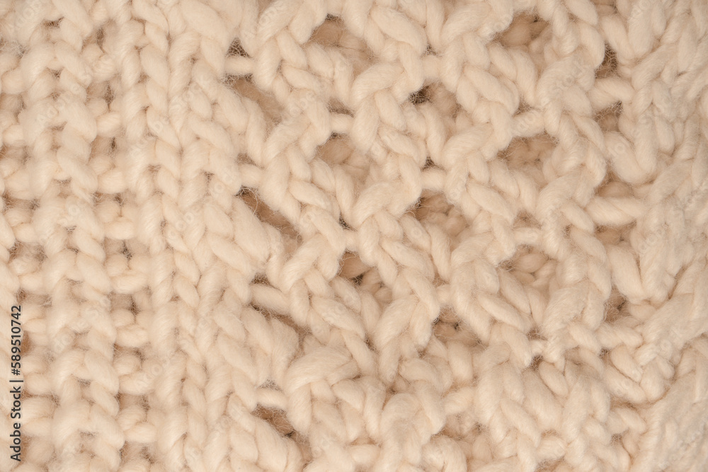 A fragment of beige knitted fabric, knitted from white sheep wool. A fragment of beige knitted fabric, knitted from white sheep wool.