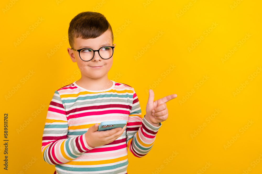 Photo of charming pupil wear stylish striped clothes demonstrate look empty space interesting offer isolated on yellow color background