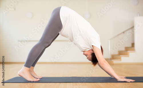Pregnant woman is engaged in yoga. Downward Dog Pose or Adho Mukha Svanasana