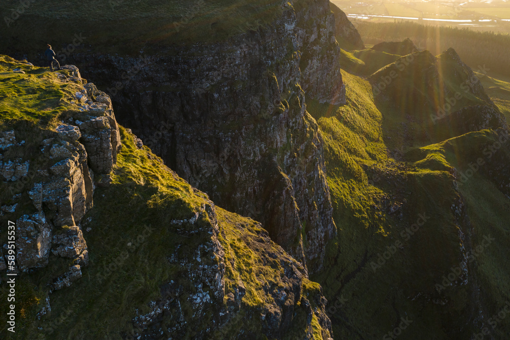 Man standing on the cliff edge of Binevenagh mountain, County Antrim, Ulster, Northern Ireland Man standing on the cliff edge of Binevenagh mountain, County Antrim, Ulster, Northern Ireland