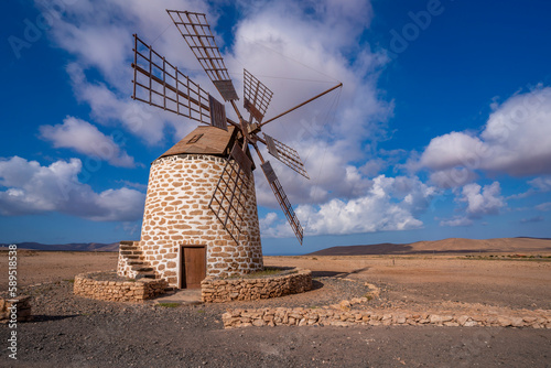 View of traditional windmill and landscape on a sunny day, La Oliva, Fuerteventura photo