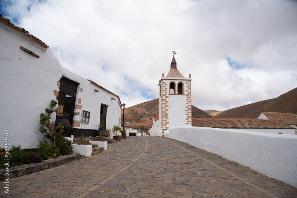 Vista panorámica de las antiguas calles del pueblo de Betancuria en Fuerteventura, con suelo de piedra y edificios blancos en un día nublado en las Islas Canarias.