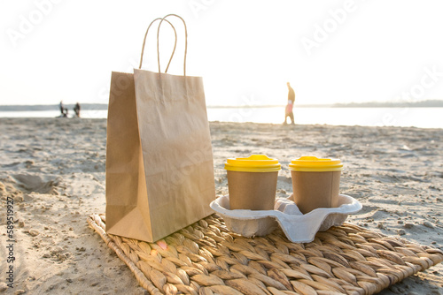 kraft bag and paper cups for coffee on the river or sea shore
