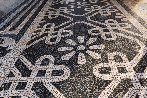 Tile brick floor in Lisbon, Portugal. Traditional old type mosaic on the sidewalk or pavement in the city