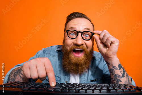 Portrait of crazy geek developer using computer coding searching web shopping sales isolated on shine color background photo