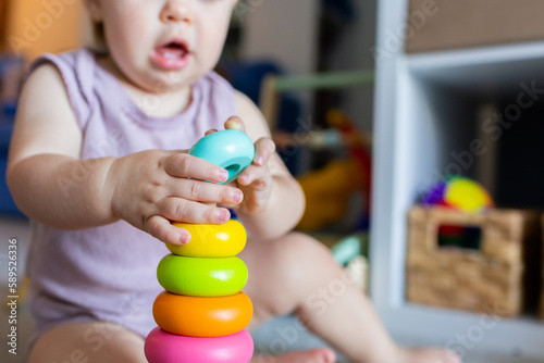 Baby learning through play developing fine motor skills with colourful stacking toy photo