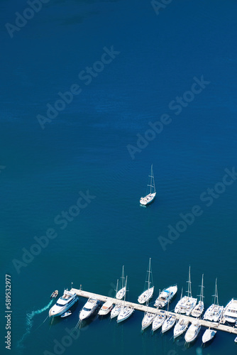 Aerial drone view of marina with ships and boats and pier and turquoise sea water. Abstract background texture