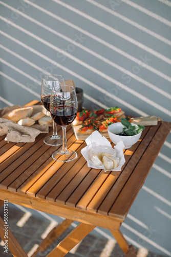 Red wine on summer terrace during golden hour. Outdoors eating concept. Copy space. Italian weekends.