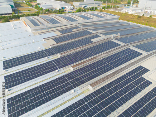 Aerial view of solar panels or solar cells on the roof of factory building rooftop. Power plant, renewable clean energy source. Eco technology for electric power in industry.